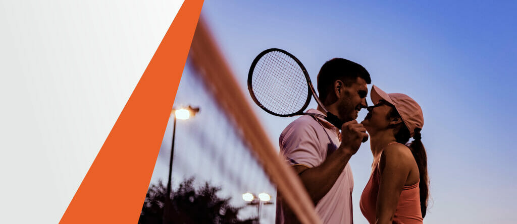 Male and Female Tennis Player Standing Next to Each Other Over the Net