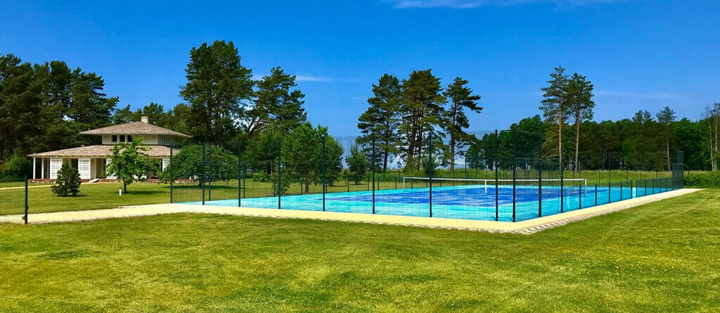 Blue Artificial Grass Surface Tennis Court Installed on a Beautiful Countryside