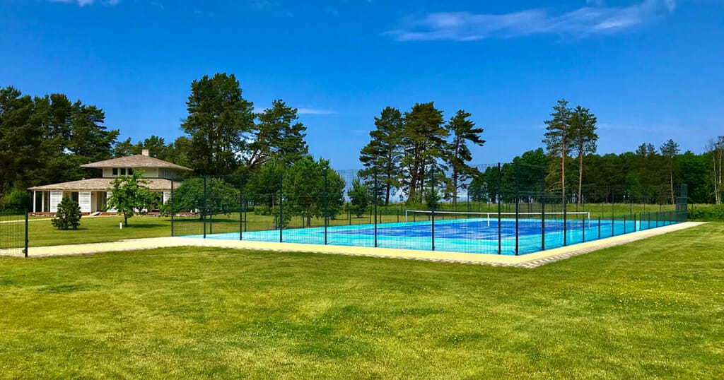 Blue Artificial Grass Surface Tennis Court Installed on a Beautiful Countryside