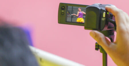 Filming a girl playing tennis with a camera to get tennis tips from coaches.